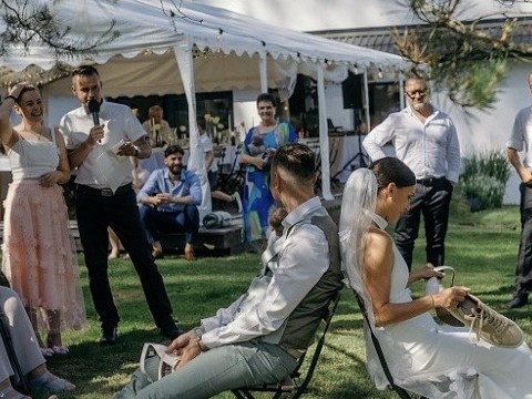Jan Císař moderuje svatební hru s botami v zahradě